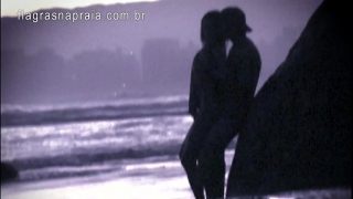 Casal trepando na praia